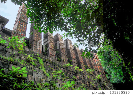 愛知・常滑の登り窯煙突群と石垣、歴史を刻む煉瓦と深緑が調和する陶磁器の街の景観 131520559