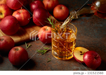 Apple kombucha is poured from a bottle into a glass. Apple kombucha is poured from a bottle into a glass. 131521560