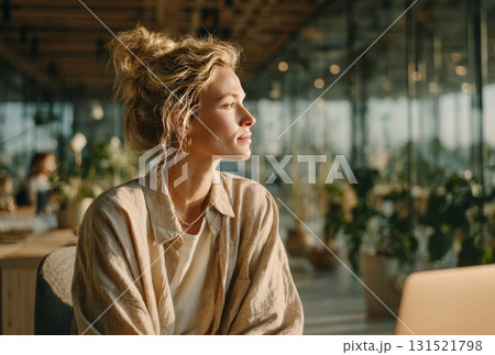 Young woman contemplating, looking away in sunny office Young woman contemplating, looking away in sunny office 131521798
