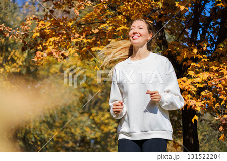 Young beautiful girl jogging in city beautiful autumn park and forest enjoy outdoor sports.  131522204