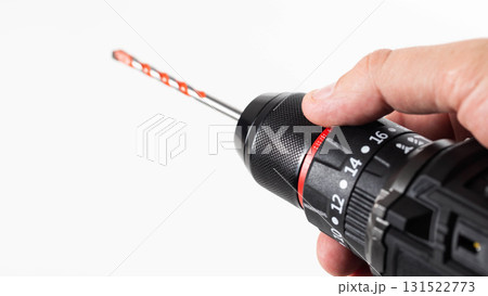 Hand holding a black and red power drill with a drill bit ready for use at a home improvement project, isolate Hand holding a black and red power drill with a drill bit ready for use at a home improvement project, isolate 131522773