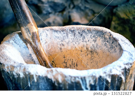 An old mortar with a wooden handle for grinding flour, close-up An old mortar with a wooden handle for grinding flour, close-up 131522827