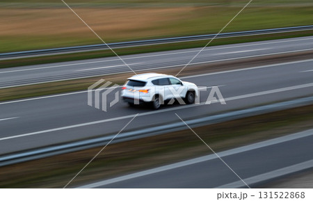 Fast-moving white SUV on a highway during early evening with blurred background 131522868