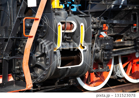 Large metal wheels of a steam locomotive transmitting traction from the locomotive to the rails, industry, close-up Large metal wheels of a steam locomotive transmitting traction from the locomotive to the rails, industry, close-up 131523078
