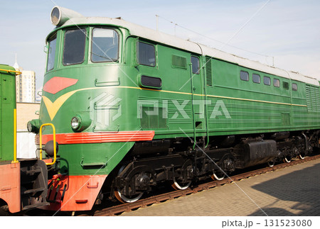 Historic green train engine on display at a railway museum showcasing classic transportation history in a city setting Historic green train engine on display at a railway museum showcasing classic transportation history in a city setting 131523080