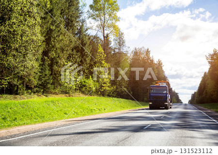A modern truck with a lowboy semitrailer transports large-sized equipment. Copy space for text, industry 131523112