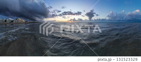 A Serene Ocean Sunset with Dramatic and Colorful Clouds in the Evening Sky Above the Horizon 131523329