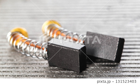 Electric motor brushes on gray background, macro, industry. Copy space for text Electric motor brushes on gray background, macro, industry. Copy space for text 131523403