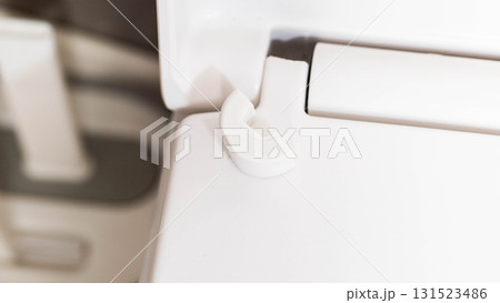Broken hinge on white toilet seat and lid, close-up, industry, low quality plastic Broken hinge on white toilet seat and lid, close-up, industry, low quality plastic 131523486