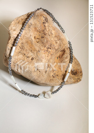 Costume jewelry necklace featuring beads and heart pendant on silk fabric background 131523711