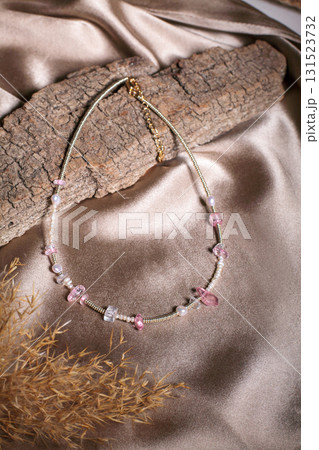 Elegant costume jewelry necklace with pink beads and soft silk background 131523732