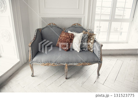 Elegant vintage sofa with decorative pillows in bright interior setting 131523775