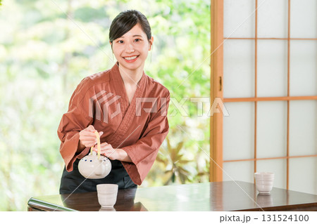 温泉旅館の客室でお茶を淹れる旅館スタッフ・仲居さんの女性 131524100