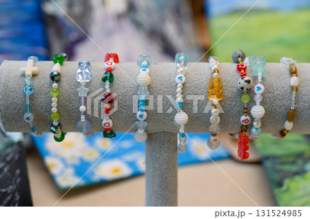 A collection of children's bracelets made of beads and pendants on a gray holder 131524985