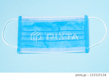 Blue medical mask, top view on blue background, healthcare, safety, and protective face mask concept Blue medical mask, top view on blue background, healthcare, safety, and protective face mask concept 131525138