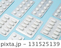 Pill blister packs laying in a rows on blue background. Treatment and medication concept. Blister packages. 131525139