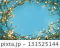 Christmas string lights glowing on blue background, festive holiday garland decoration, top view celebration concept 131525144
