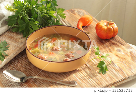 Traditional Italian minestrone soup with vegetables, sausage, and pasta, served in clay bowl on wooden board. Food and healthy lifestyle. Mediterranean cuisine. Traditional Italian minestrone soup with vegetables, sausage, and pasta, served in clay bowl on wooden board. Food and healthy lifestyle. Mediterranean cuisine. 131525715