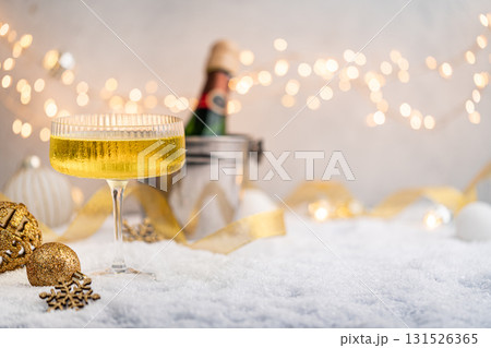 Champagne Glass and Bottle on Snow with Festive Lights Champagne Glass and Bottle on Snow with Festive Lights 131526365