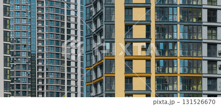 Close up of modern high rise residential tower. Multiple glass windows and balconies create Close up of modern high rise residential tower. Multiple glass windows and balconies create 131526670