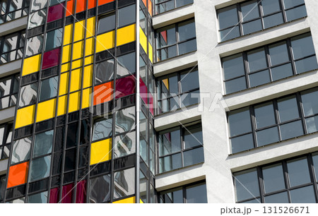 Close up of modern high rise residential tower. Multiple glass windows and balconies form colorful Close up of modern high rise residential tower. Multiple glass windows and balconies form colorful 131526671