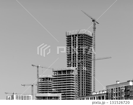 Construction of tall modern high rise tower in urban district. Unfinished concrete and steel Construction of tall modern high rise tower in urban district. Unfinished concrete and steel 131526720
