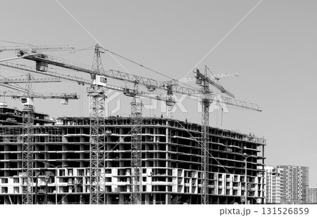 monochrome view of cranes over tall high rise tower in metropolitan district. Modern multistory monochrome view of cranes over tall high rise tower in metropolitan district. Modern multistory 131526859