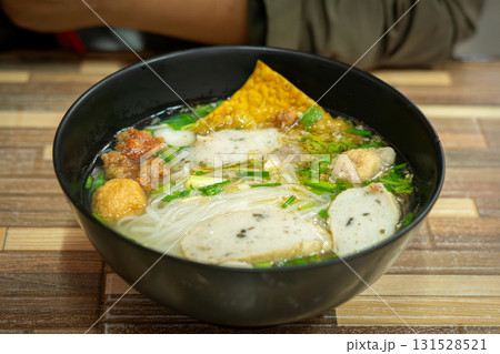 Traditional Thai Noodle Soup with Fish Balls and Crispy Wonton in Black Bowl Traditional Thai Noodle Soup with Fish Balls and Crispy Wonton in Black Bowl 131528521