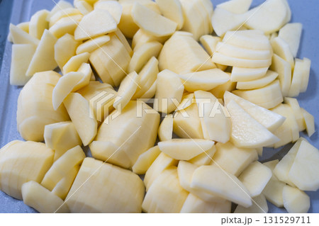Slice potato on cutting board with knife. Cooking meal 131529711