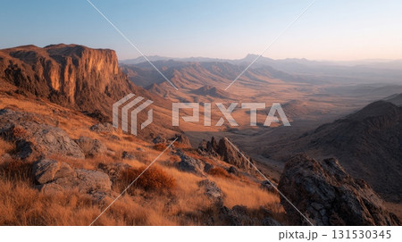 Sunset View Of Expansive Mountain Landscape With Rocky Cliffs And Dry Grass. Captures The Serene Beauty Of Nature'S Vastness 131530345