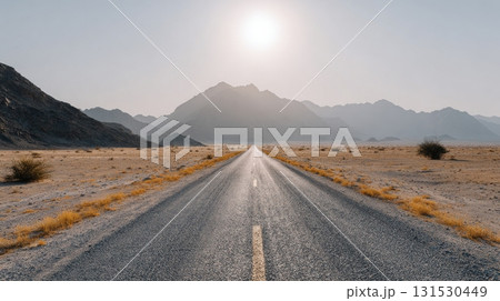 Desert Road Leading To Mountains Under Bright Sun. Journey Into The Vast Wilderness 131530449