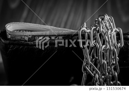 The black wallet is firmly locked with a chain and a lock 131530674