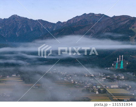早朝の五竜岳・唐松岳と雲海に透ける街並み　長野県白馬村（ドローンによる空撮） 131531934