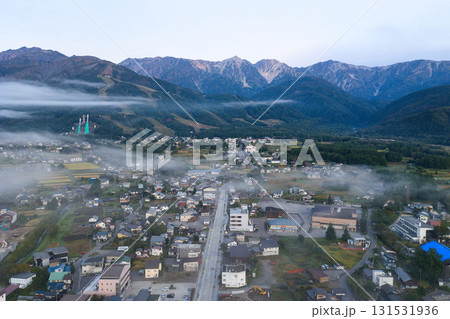 早朝の白馬三山と雲海に透ける街並み　長野県白馬村（ドローンによる空撮） 131531936