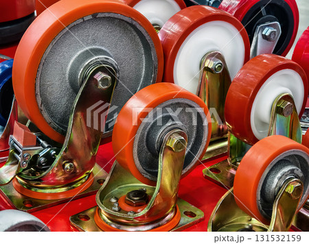 Different types of industrial wheels and casters arranged neatly on a display table in a workshop setting 131532159