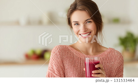 Smiling woman holding a healthy detox smoothie in a bright kitchen Smiling woman holding a healthy detox smoothie in a bright kitchen 131533464