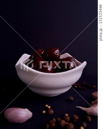 A bowl of black olives, still life with olives, garlic, and spices. A bowl of black olives, still life with olives, garlic, and spices. 131533496