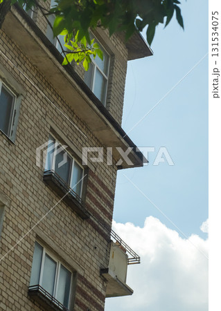 A tall brick building stands proudly against a clear blue sky background 131534075