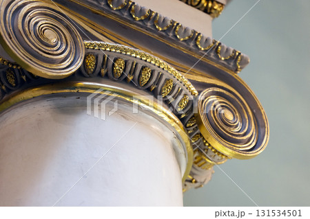Close-up of gilded scrollwork and decorative bands around a white column Close-up of gilded scrollwork and decorative bands around a white column 131534501