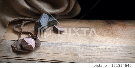 An antique leather sling lies on wooden desk 131534649