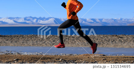 Woman runner training at winter lakeside Woman runner training at winter lakeside 131534695