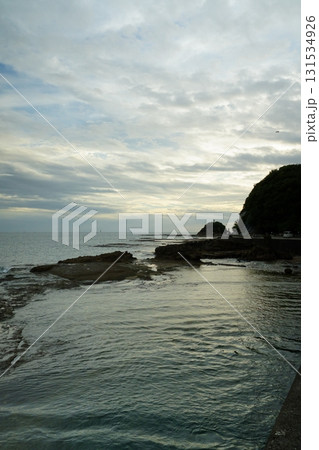 潮が引いた遠浅の海岸と遠くに見える海と空と雲 131534926