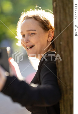 Young woman with braces smiling and holding smartphone Young woman with braces smiling and holding smartphone 131535534