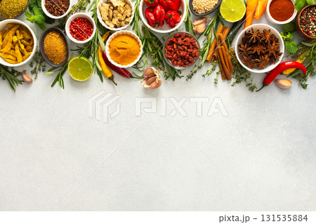 A vibrant assortment of spices and herbs on a gray background, offering a flavorful addition to any recipe, top view and copy space 131535884