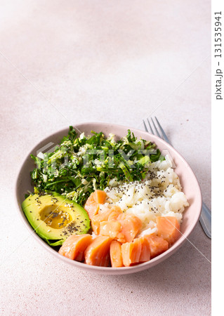 A delightful breakfast charcuterie board showcases creamy avocado, fresh salmon, and vibrant greens arranged in an appealing bowl, perfect for a healthy morning meal 131535941