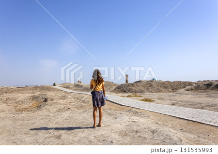 girl walk through the ruined area that destroyed by war in Uzbekistan, Bukhara during drought season 131535993