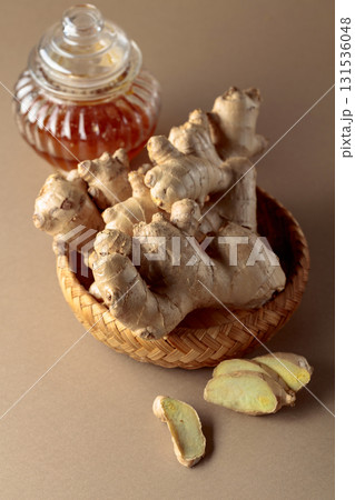 Ginger with honey jar on a beige background. Ginger with honey jar on a beige background. 131536048