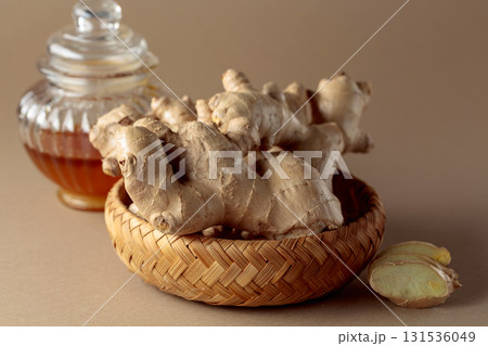 Ginger with honey jar on a beige background. Ginger with honey jar on a beige background. 131536049