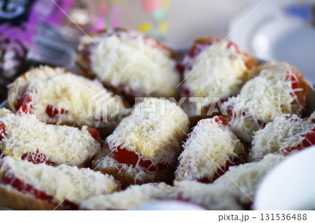 Close-up of crispy bread with melted cheese topping. Close-up of crispy bread with melted cheese topping. 131536488