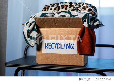 Box of used clothing marked for recycling. Eco friendly lifestyle. Closet management. 131536508